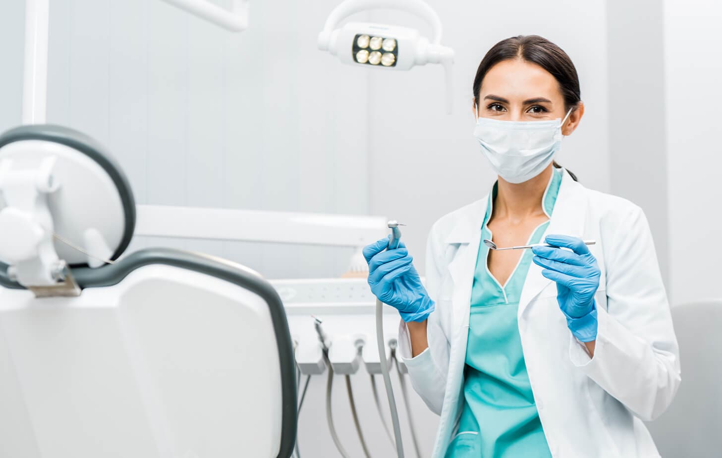 Female dentist holding dental tools.